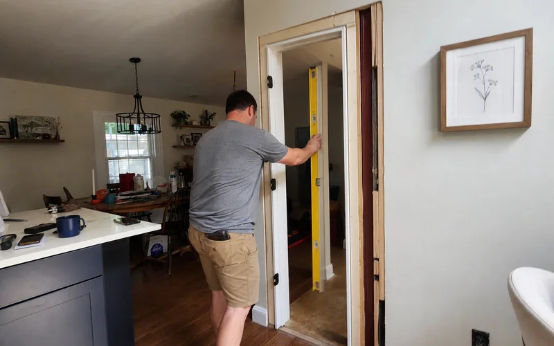 Installer checking a prehung frame for plumb