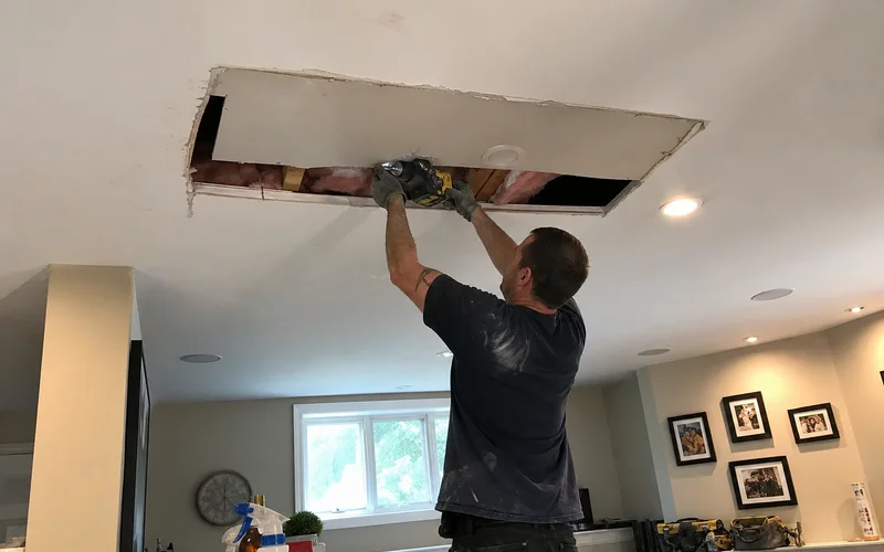 Cutting out a damaged drywall section for replacement