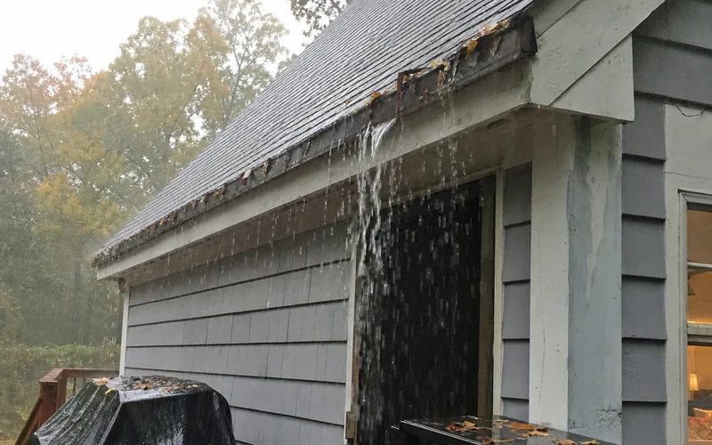 Clogged gutter overflowing onto trim