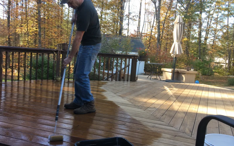 Applying clear sealant to deck boards