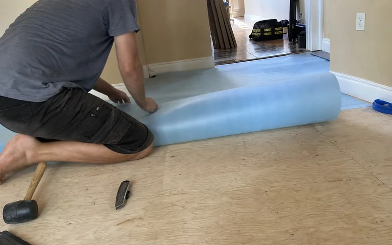 Underlayment being laid over subfloor
