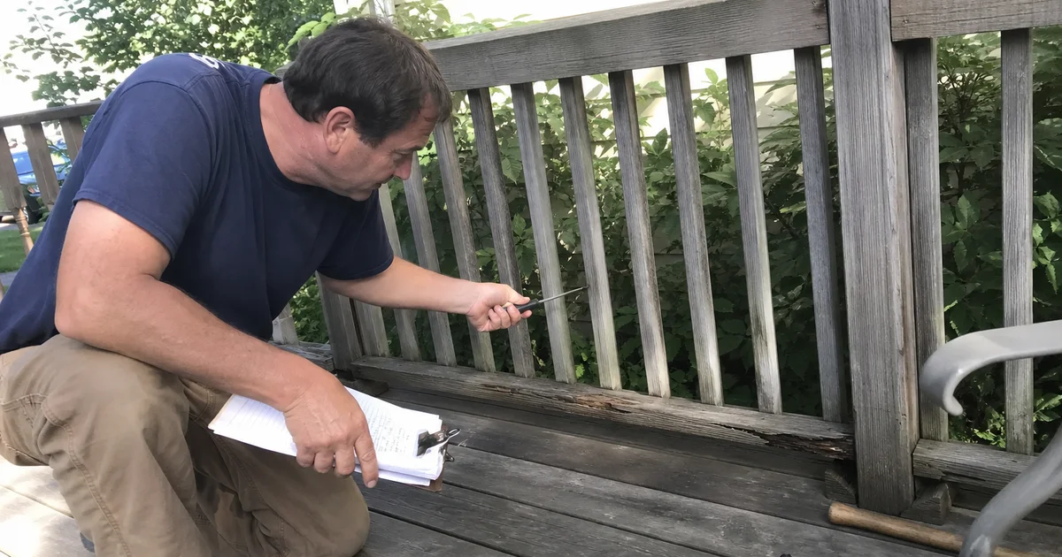 Handyman inspecting a Connecticut backyard deck for winter rot damage and loose railings